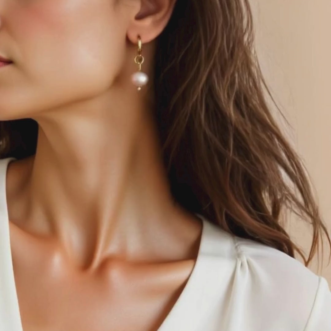 Roze parel oorbel met gouden hanger gedragen – elegante sieraden voor de bewuste vrouw