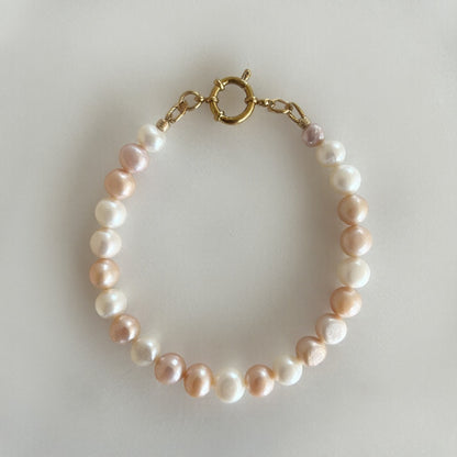 Handgemaakte parelarmband in wit en roze tinten met gouden sluiting – elegante en tijdloze sieraden
